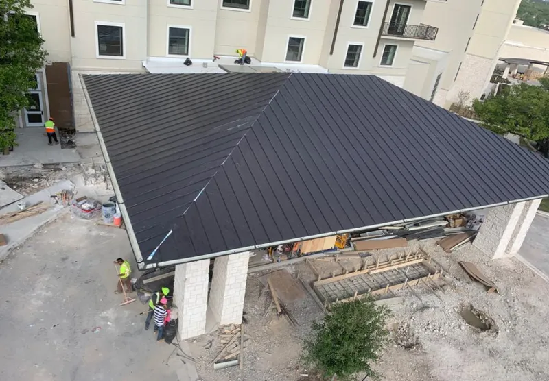 Metal roofing installation team working on a commercial building in Tucker